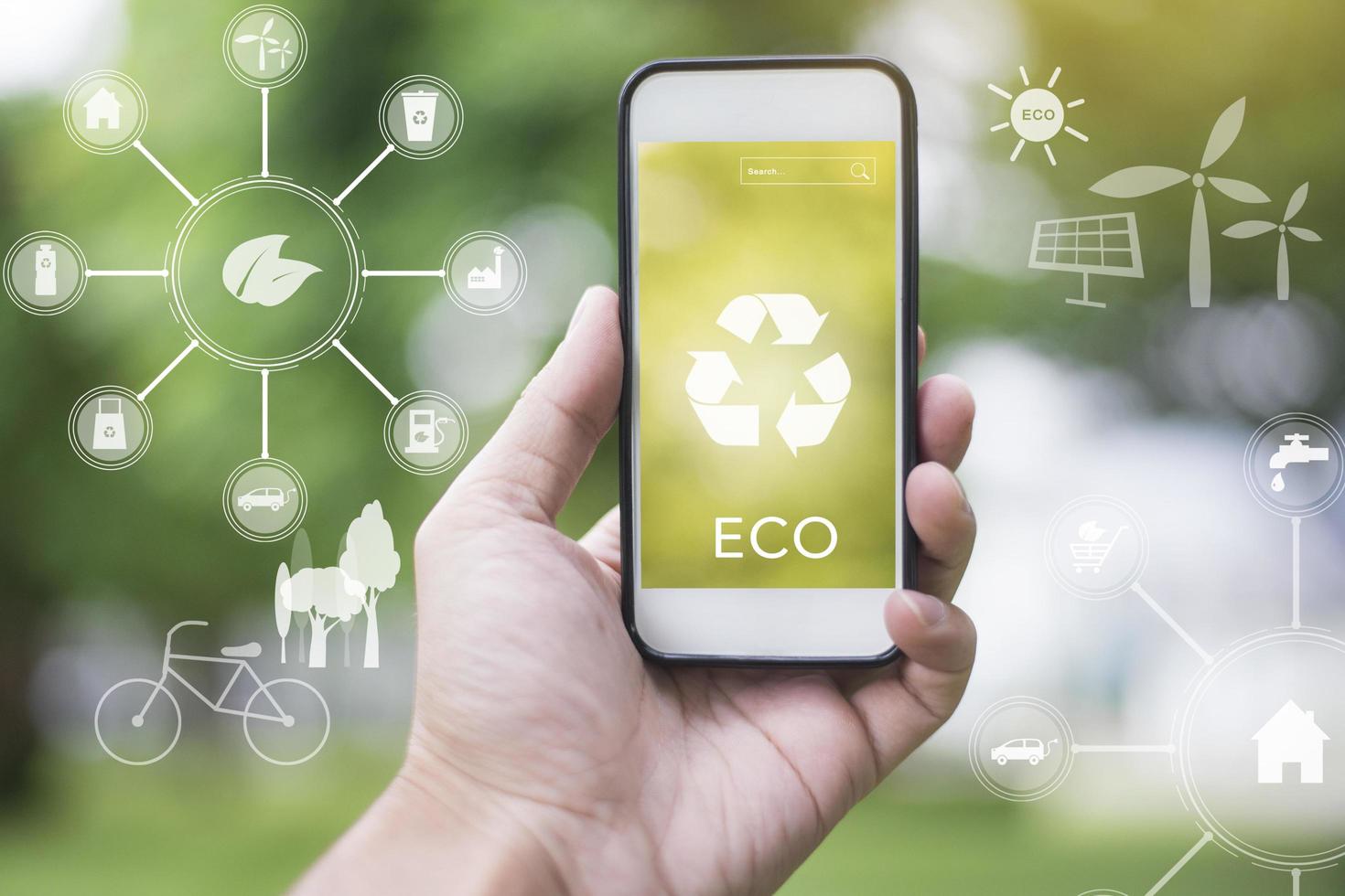 close-up man hand met smartphone op groen met ecologische pictogrammen, save earth concept foto