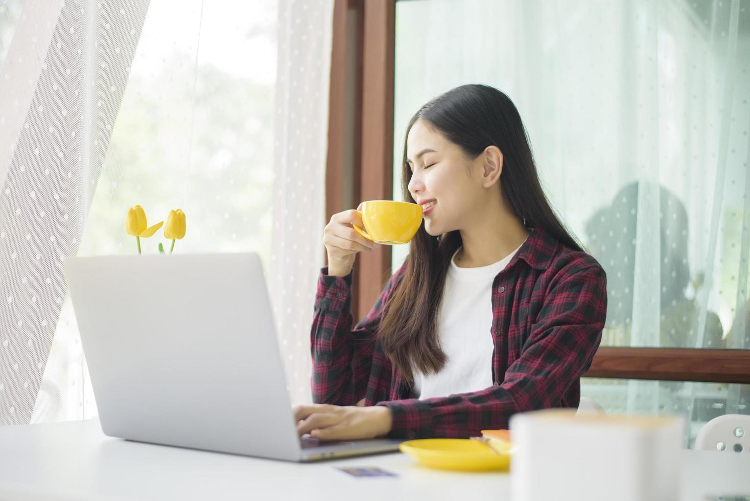 mooie vrouw werkt met laptopcomputer in coffeeshop foto