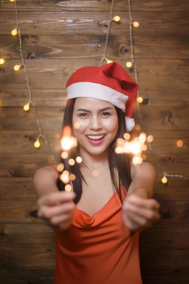 portret van een mooie vrouw die een rode kerstman draagt met sterretjes thuis, kerstmis en nieuwjaarsconcept. foto