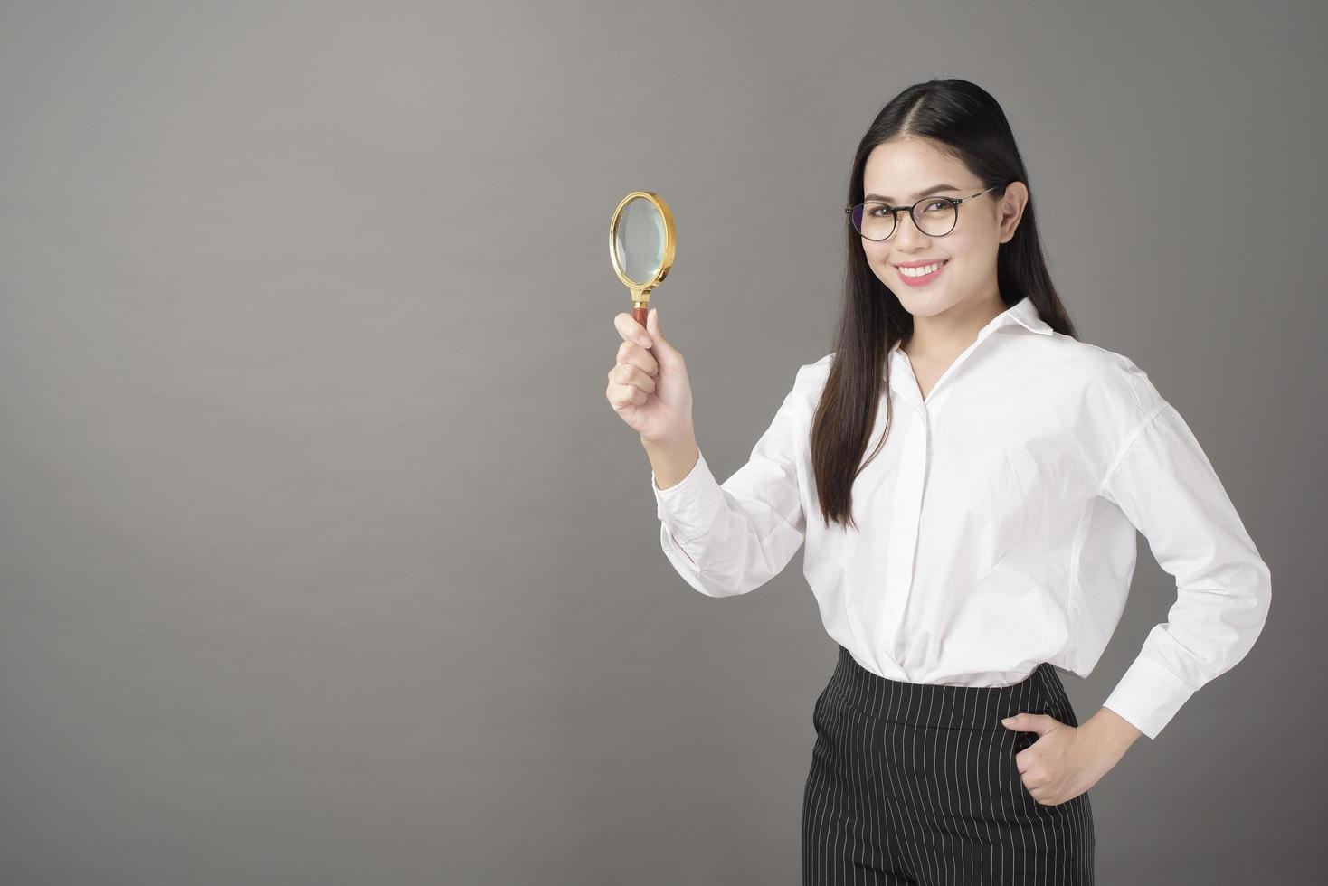 mooie vrouw houdt vergrootglas in studio foto