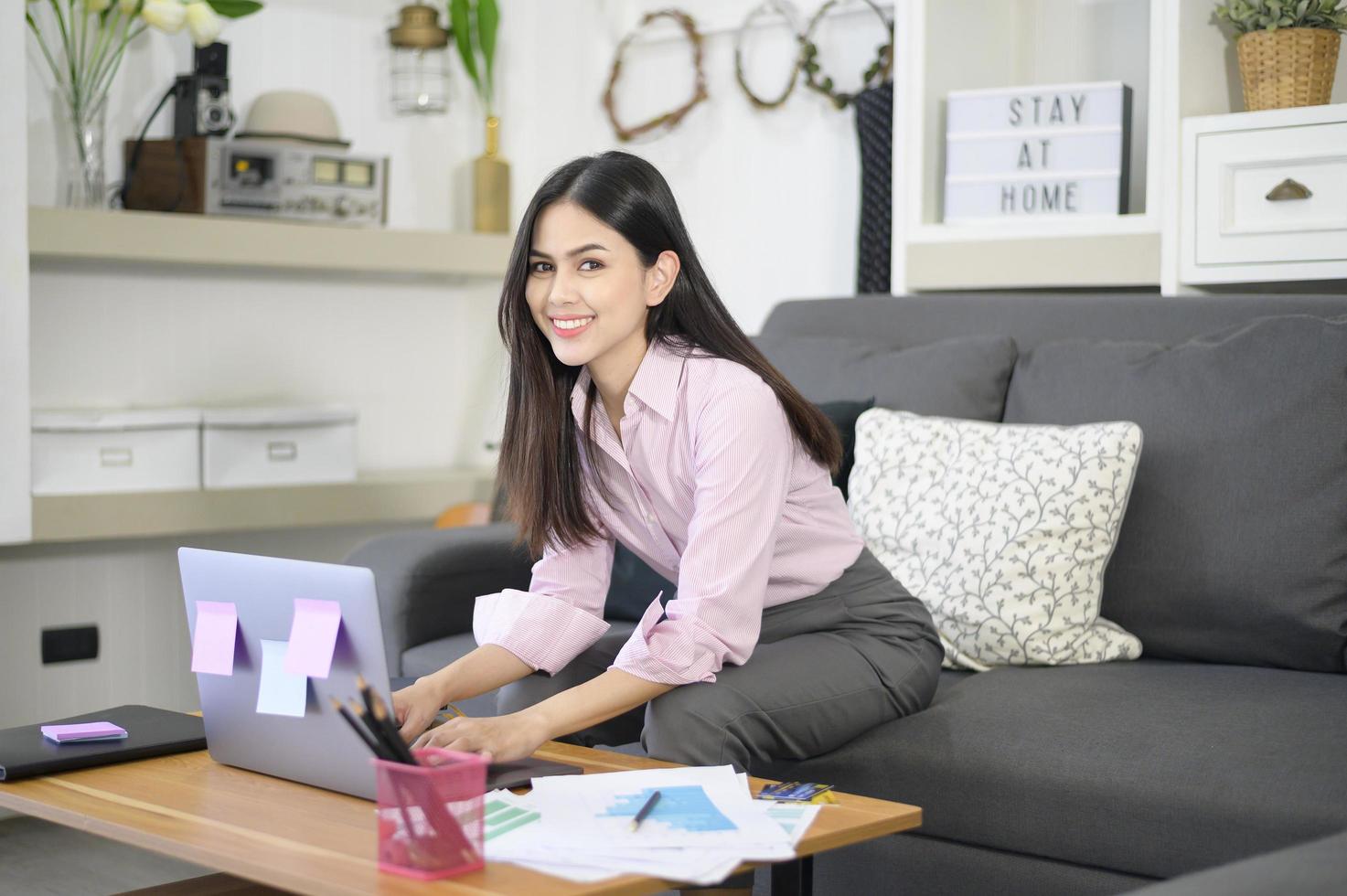 een zakenvrouw werkt met een laptopcomputer en analyseert bedrijfsgroeigrafiekgegevens in de woonkamer, werk vanuit huis, bedrijfstechnologieconcept. foto