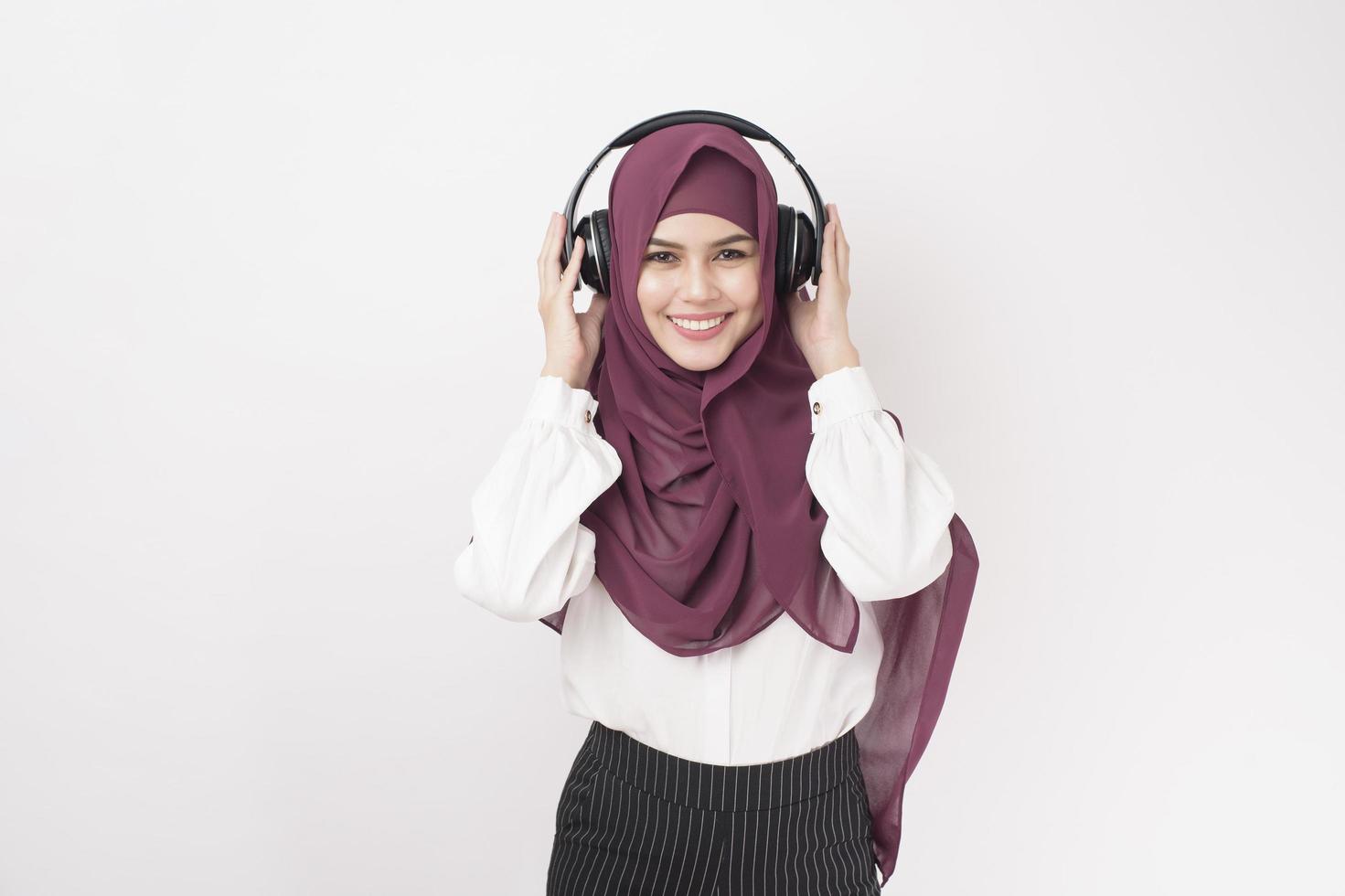 portret van mooie vrouw met hijab is genieten van het luisteren van muziek op een witte achtergrond foto