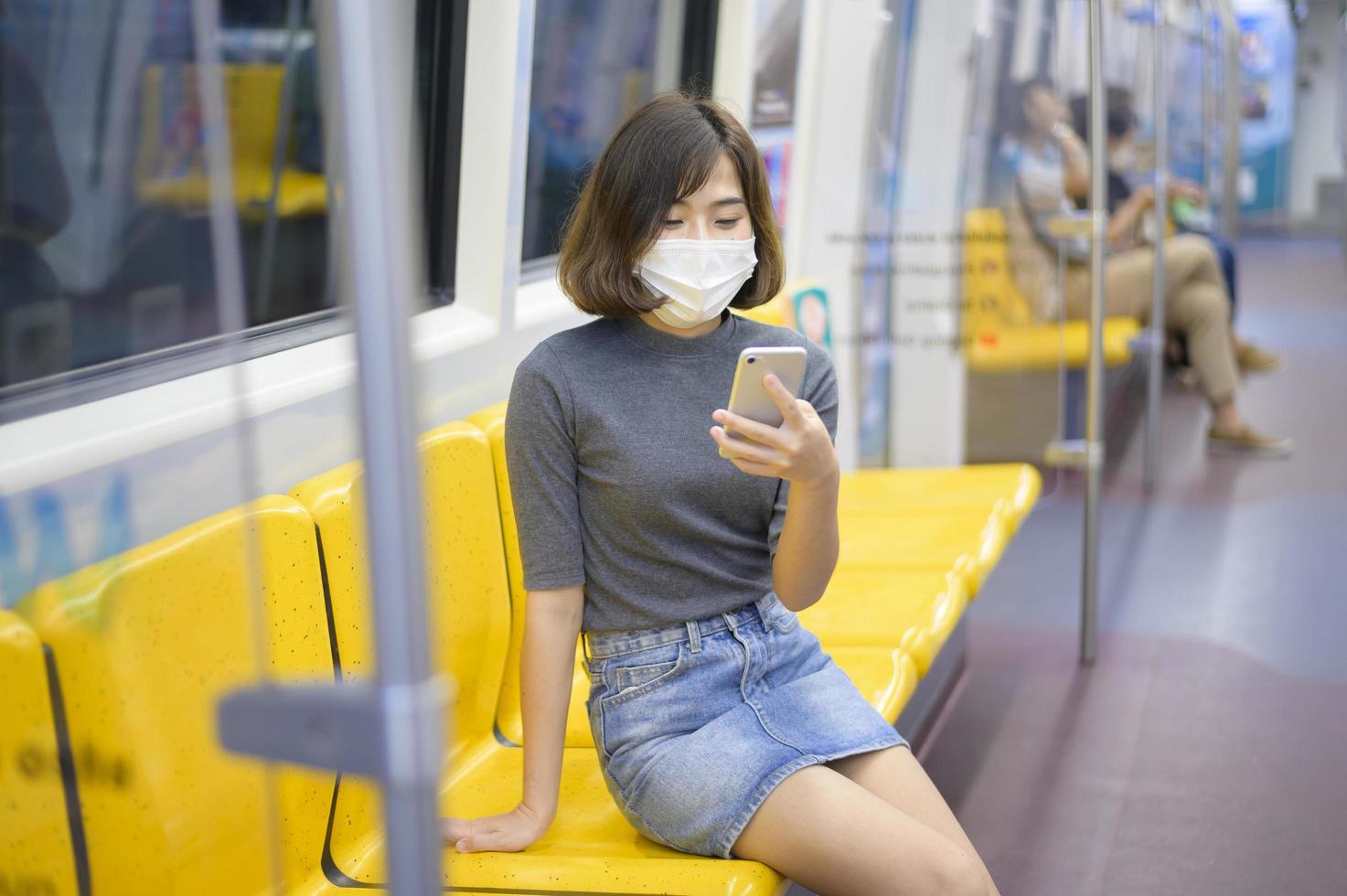 jonge vrouw draagt een beschermend masker in de metro, covid-19-bescherming, veiligheidsreizen, nieuw normaal, sociale afstand, veiligheidsvervoer, reizen onder pandemisch concept. foto
