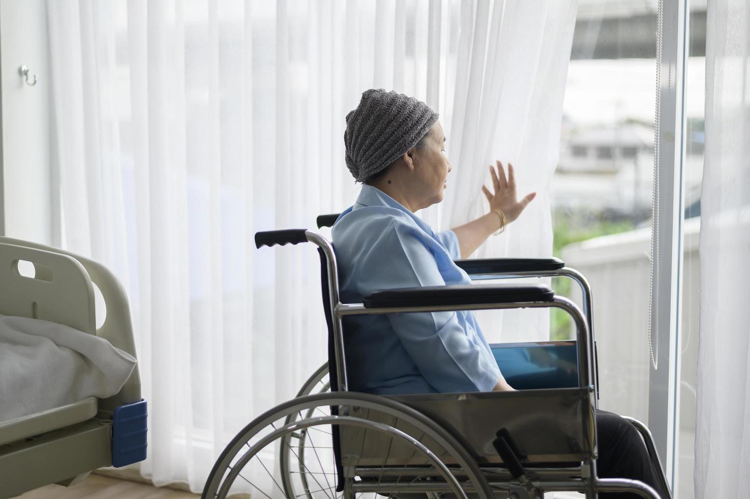 depressieve en hopeloze Aziatische kankerpatiënt vrouw met hoofddoek in het ziekenhuis. foto