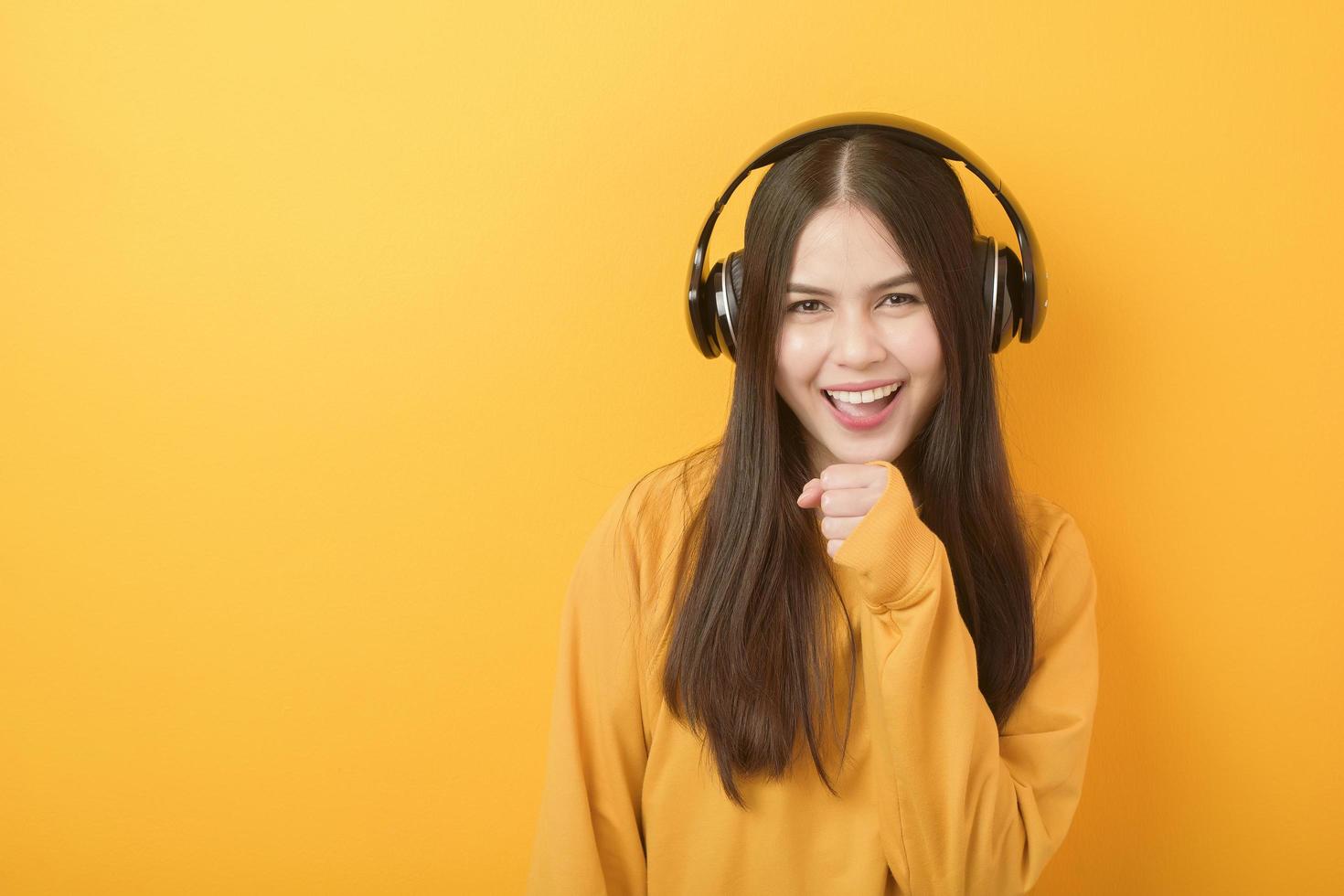 muziekliefhebber vrouw geniet met headset op gele achtergrond foto