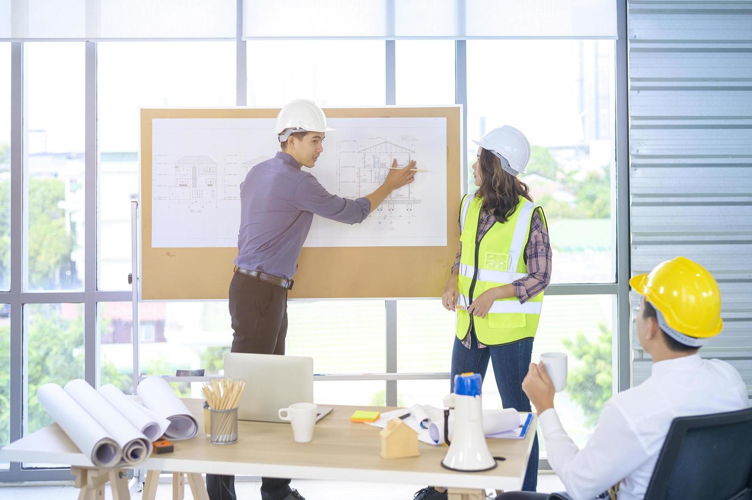 jonge mannelijke en vrouwelijke ingenieur die de ideeën presenteert en plannen bespreekt met collega's in een vergaderruimte, bedrijfsconcept voor groepsmensen foto