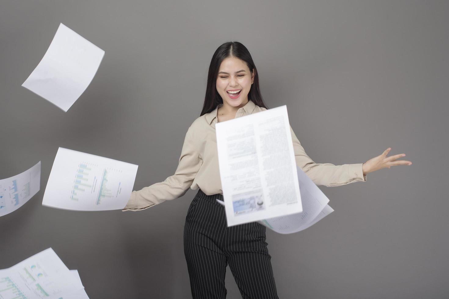 portret van mooie vrouw is blij met succesvolle zaken op grijze achtergrond foto