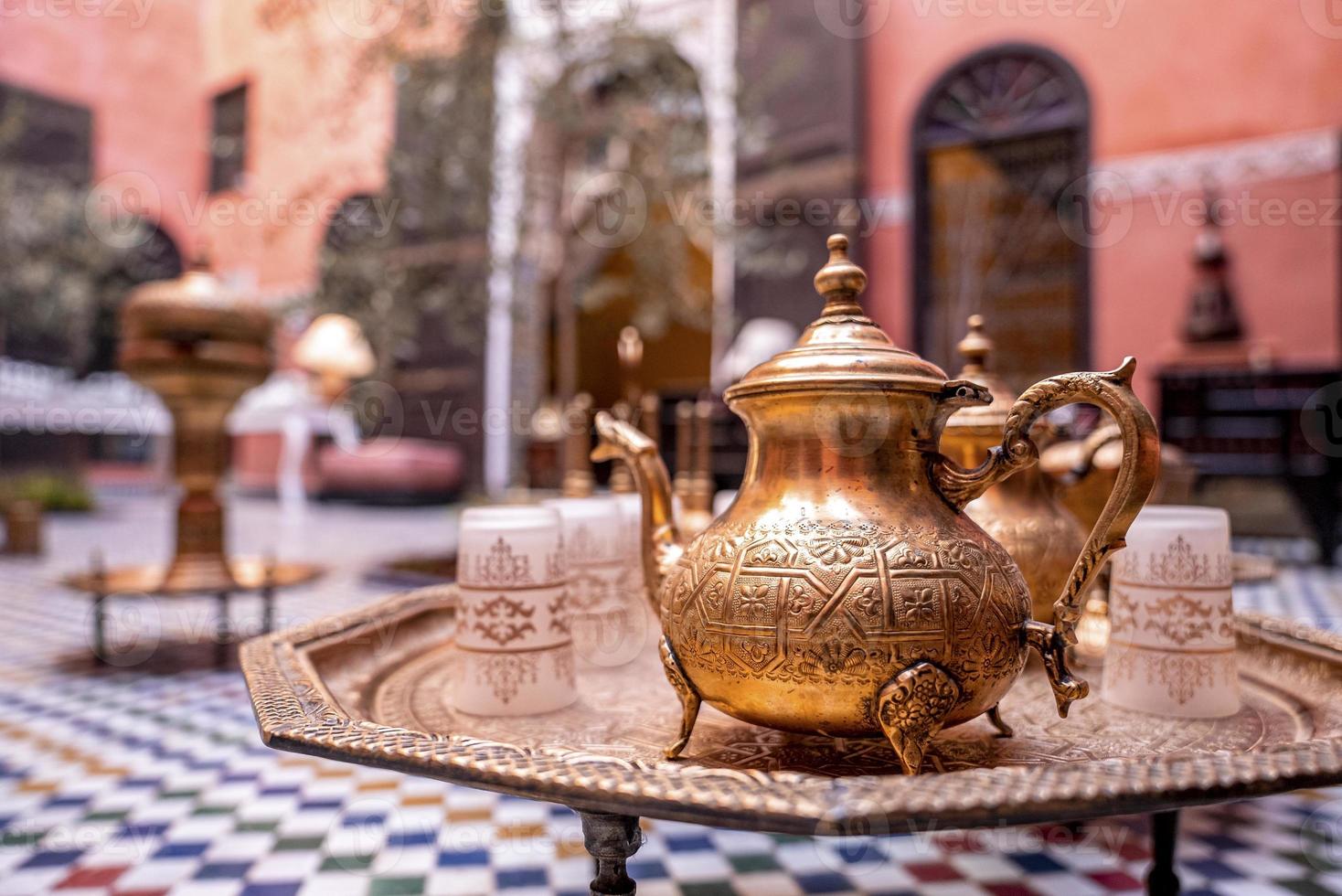 close-up van decoratieve oude metalen theepot met kopjes op tafel foto