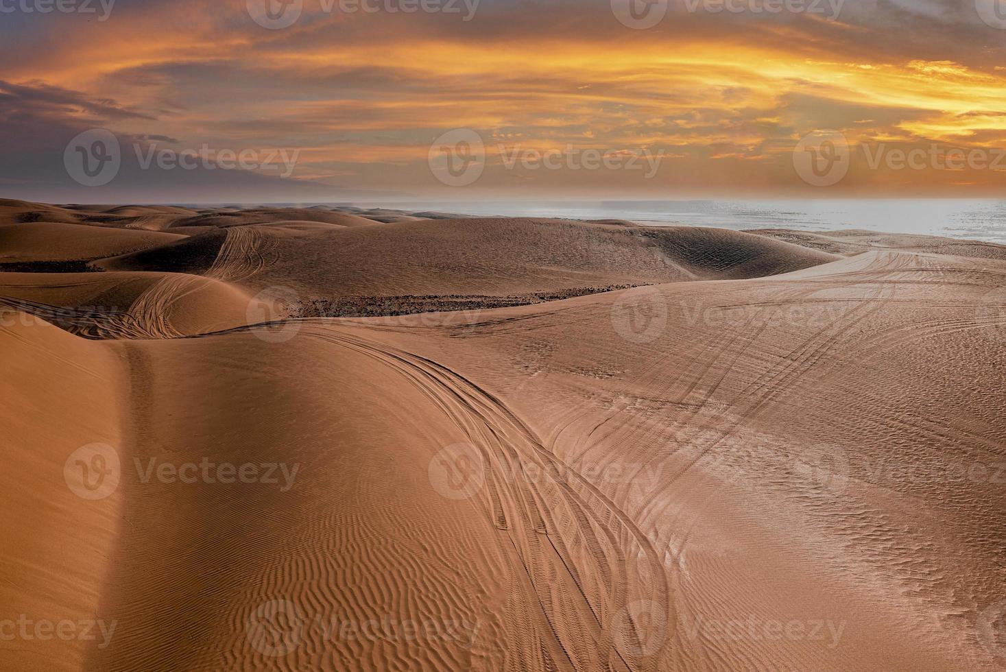 zandduinen op het strand met bandensporen in de provincie essaouira foto