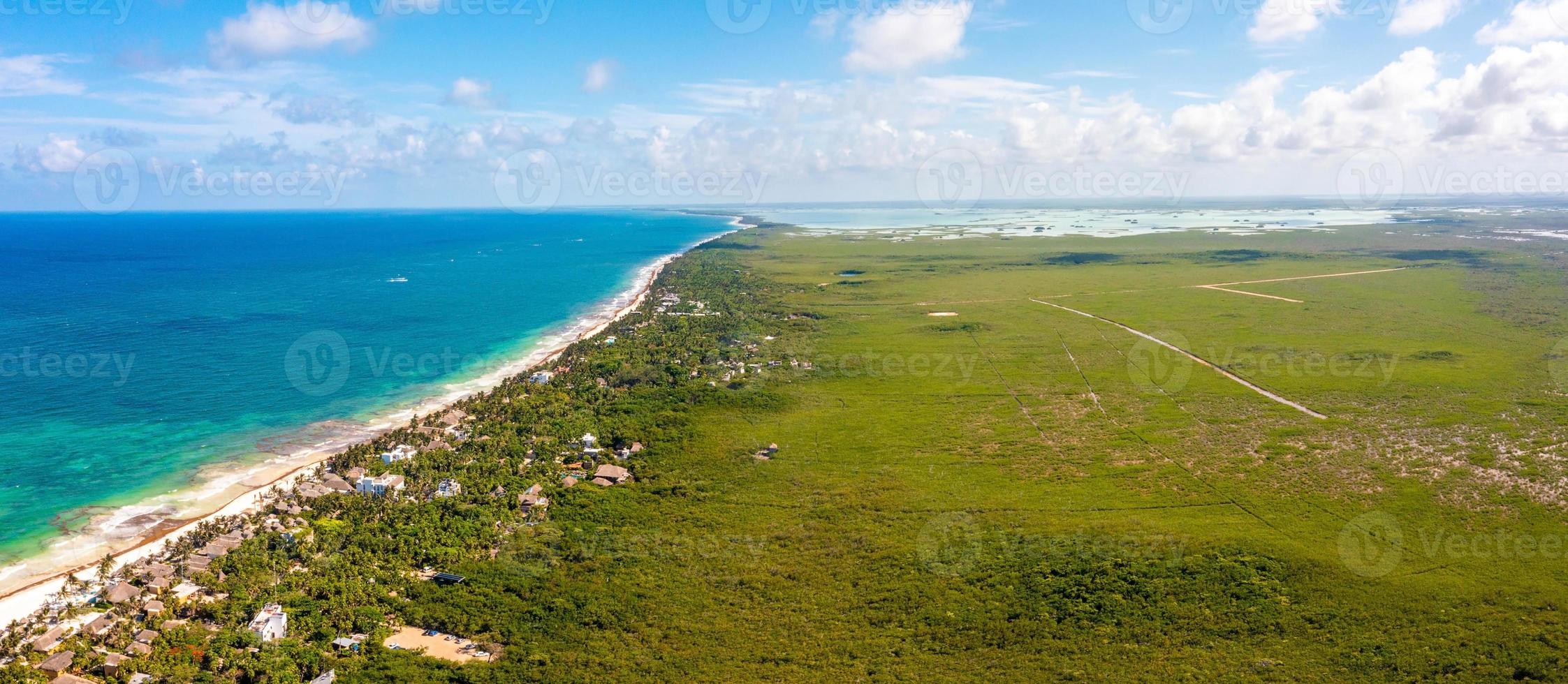 luchtfoto tulum kustlijn aan het strand met een magische Caribische zee en kleine hutten aan de kust. foto