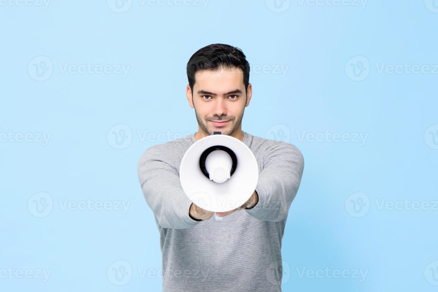 jonge knappe man met megafoon geïsoleerd op lichtblauwe achtergrond foto