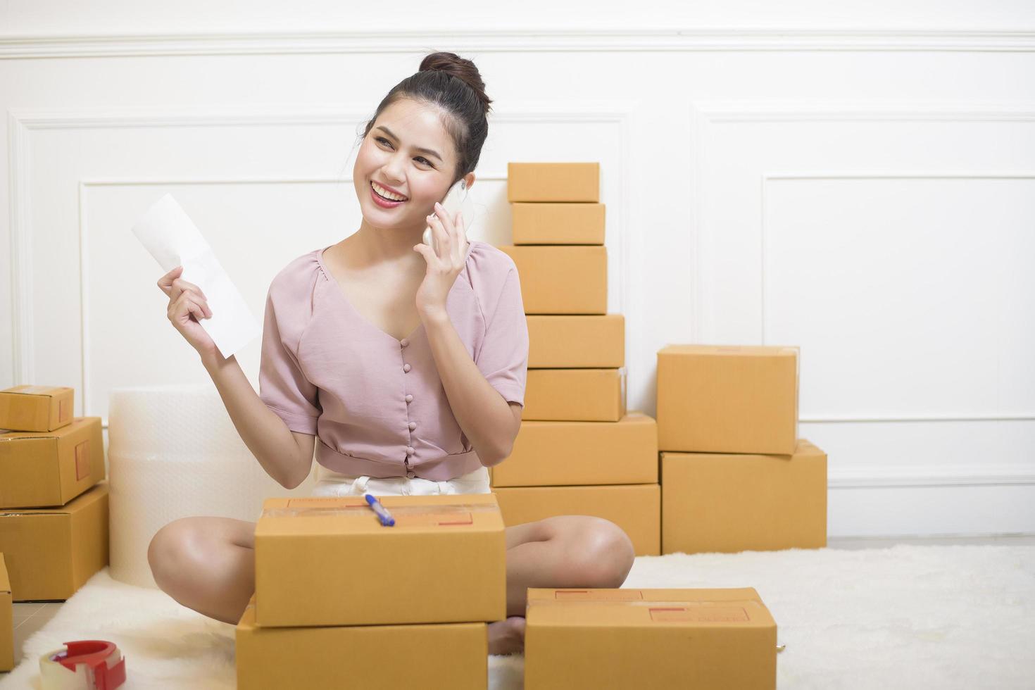 een vrouw maakt producten met kartonnen dozen klaar voor verzending. foto