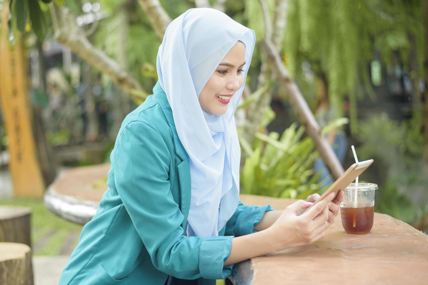 moslimvrouw met hijab werkt met laptopcomputer in coffeeshop foto