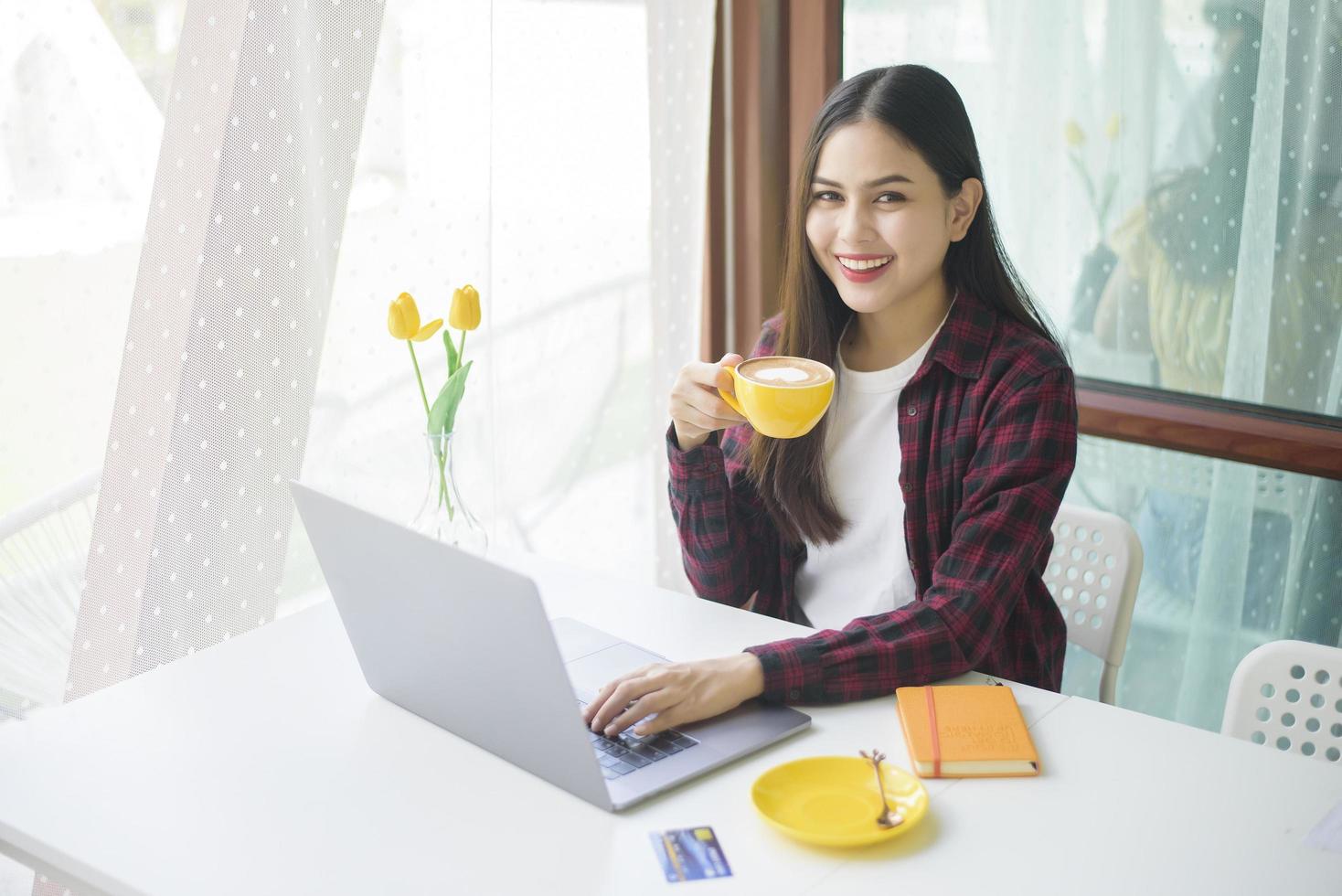 mooie vrouw werkt met laptopcomputer in coffeeshop foto
