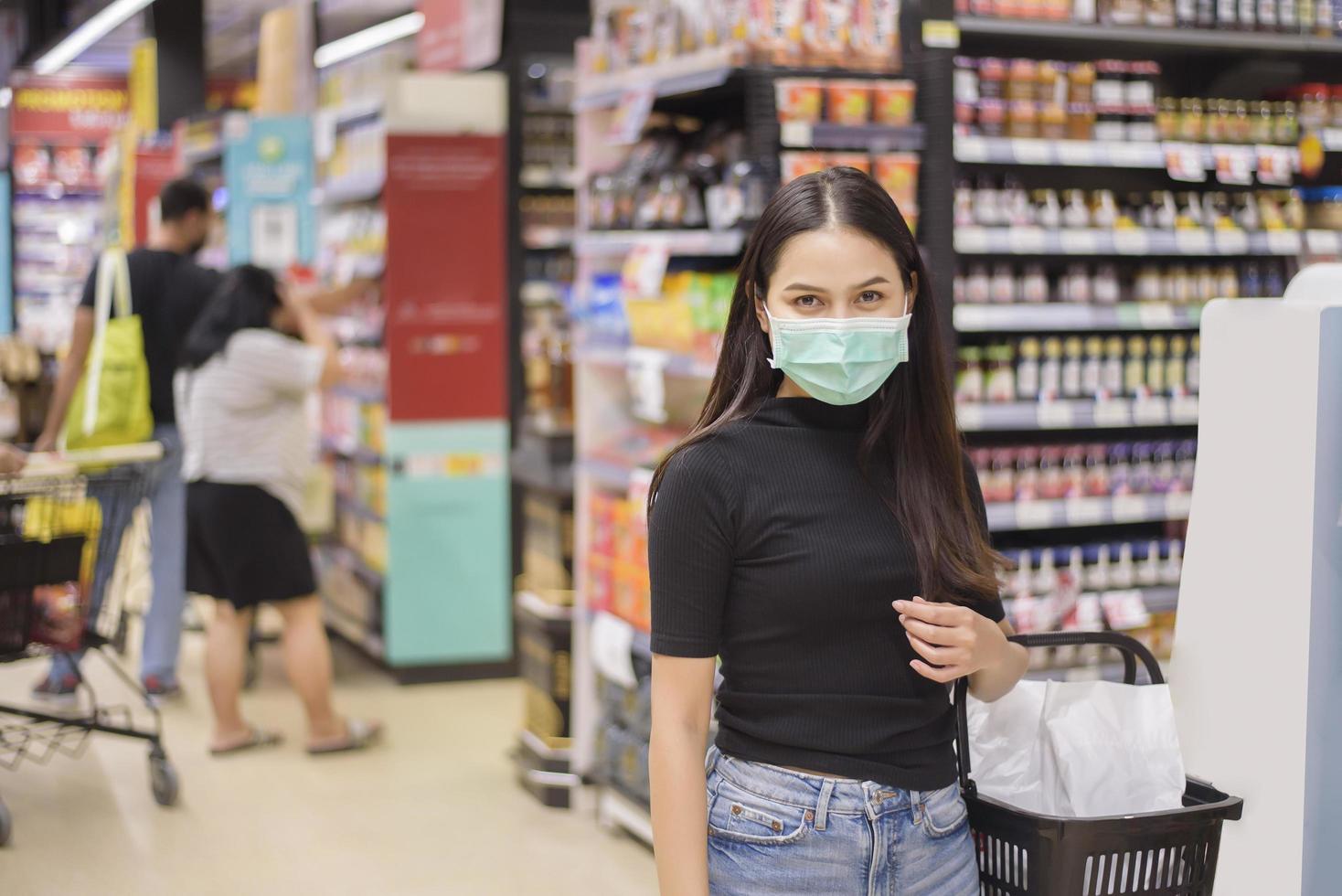 vrouw met gezichtsmasker winkelt kleren in het winkelcentrum foto