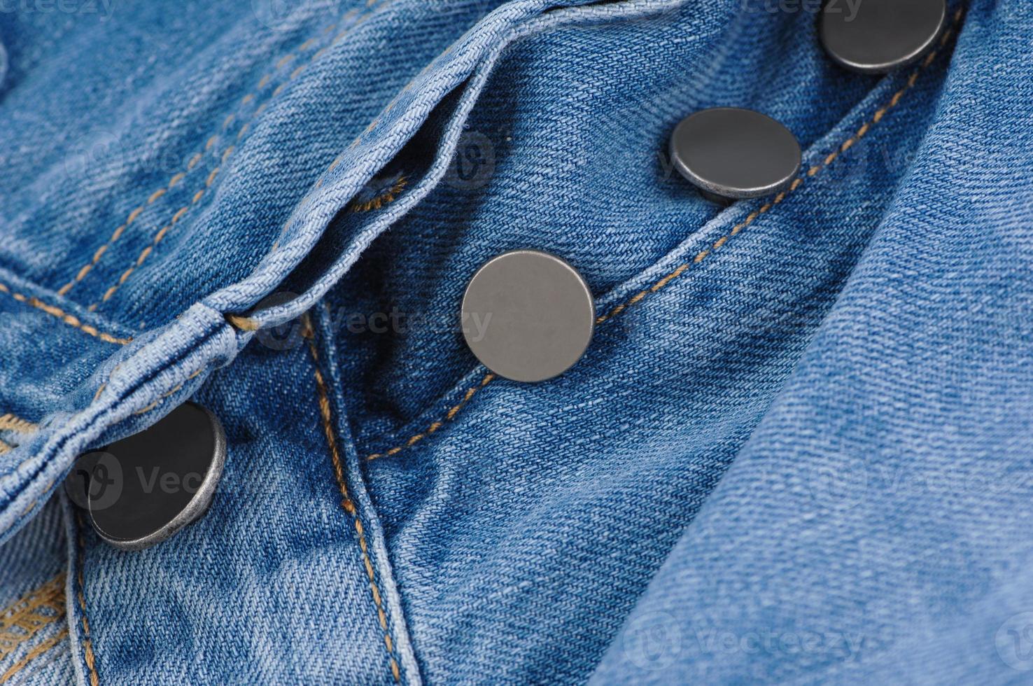 deel van denim broek met zak en losgeknoopte knopen, close-up foto