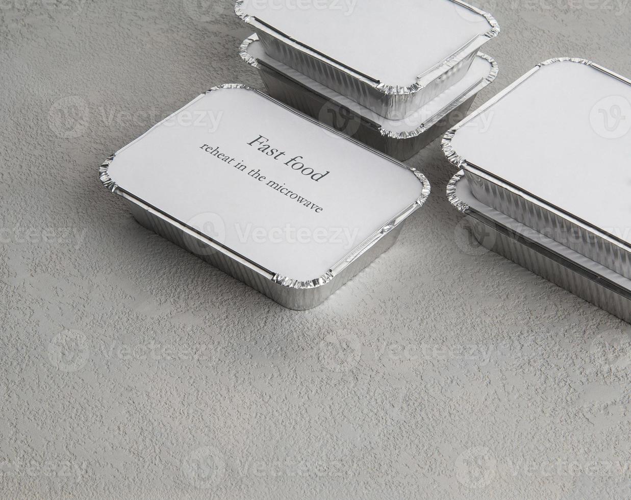 set fastfood in een doos folie op een grijze ruwe achtergrond. eten voor zakenman en drukbezette mensen foto