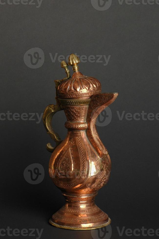 oude oosterse metalen theepot op donkere achtergrond. antiek bronzen servies foto