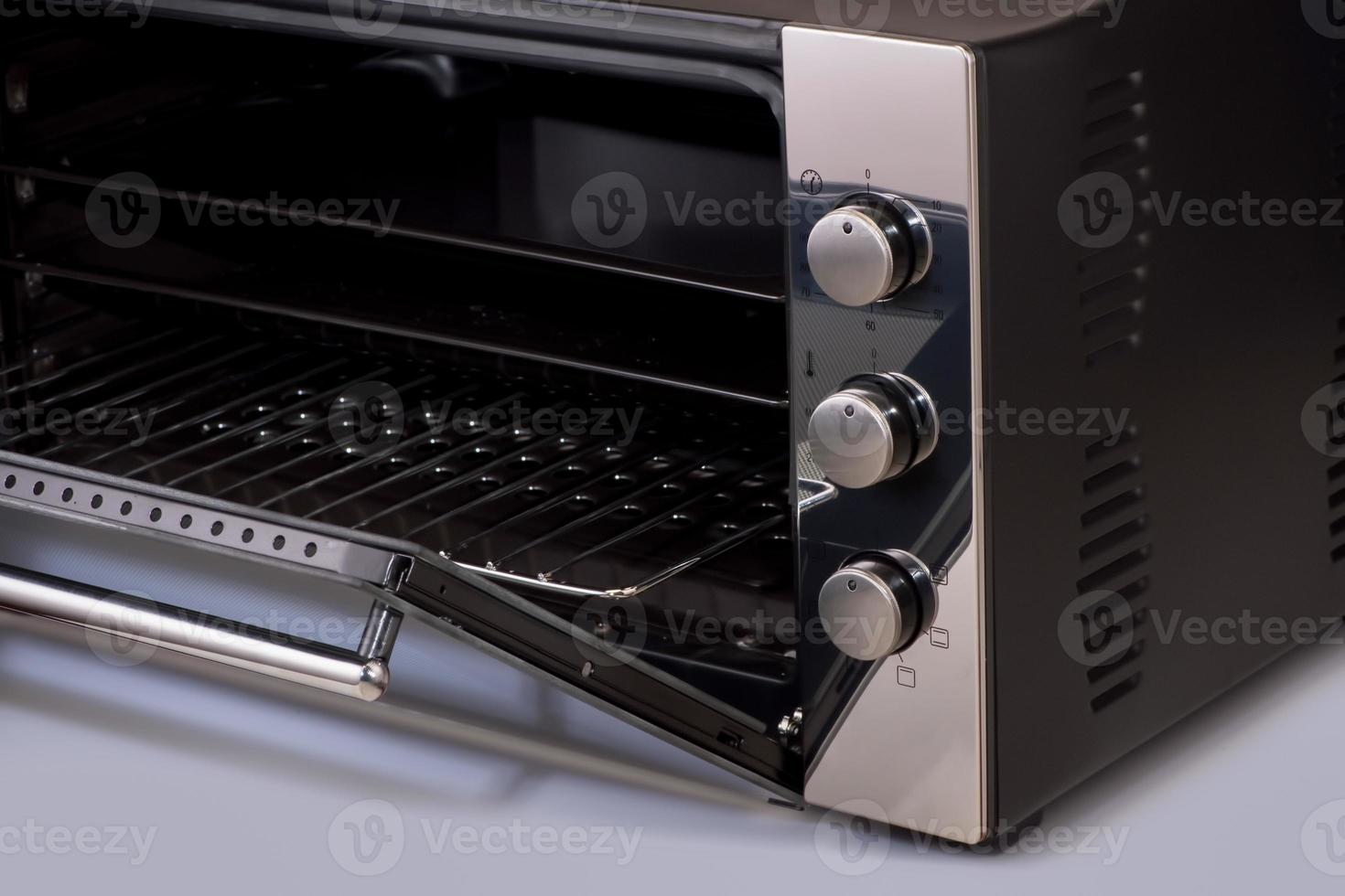 thermostaat en knoppen op een moderne magnetron, open ovendeur. keuken apparatuur foto