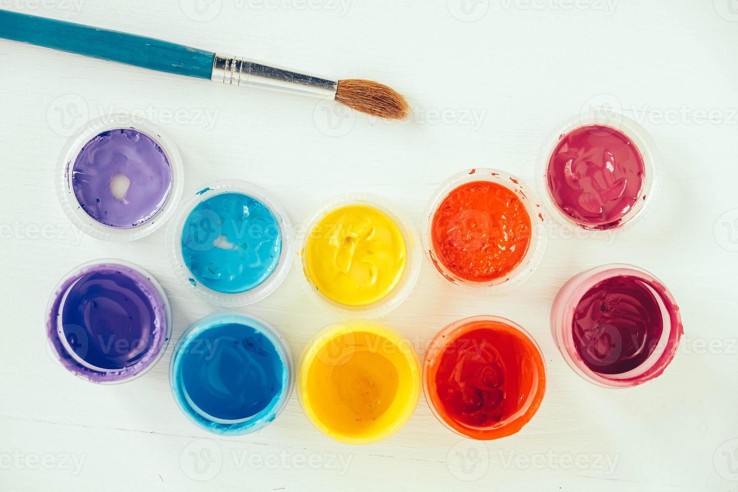 kleurrijke gouacheverven en penseel voor het schilderen op witte achtergrond foto