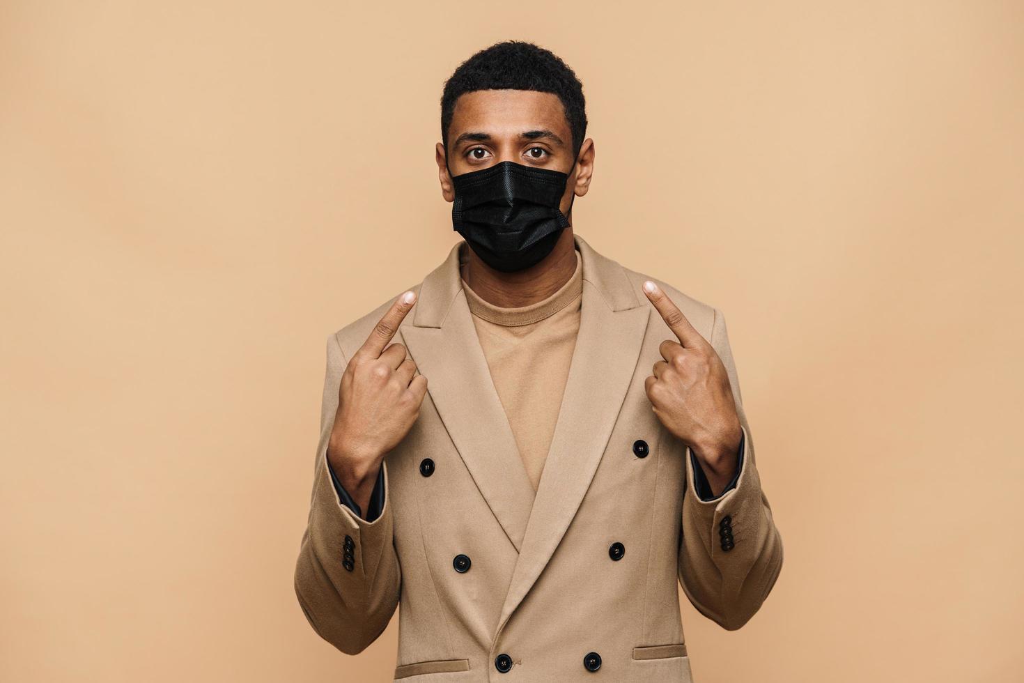 serieuze afrikaanse zakenman die zijn beschermend gezichtsmasker toont foto