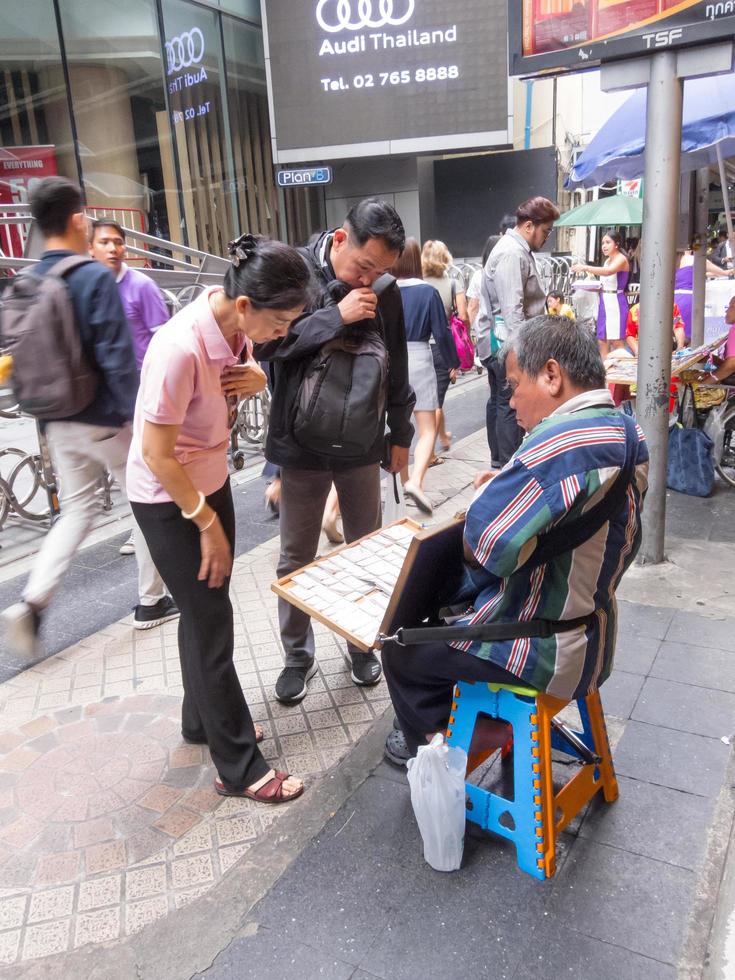 silom bangkokthailand16 augustus 2018 in de ochtend zijn mensen die loten kopen van de meeste verkopers visueel gehandicapt of anderszins lichamelijk gehandicapt. op bangkokthailand16 augustus 2018 foto
