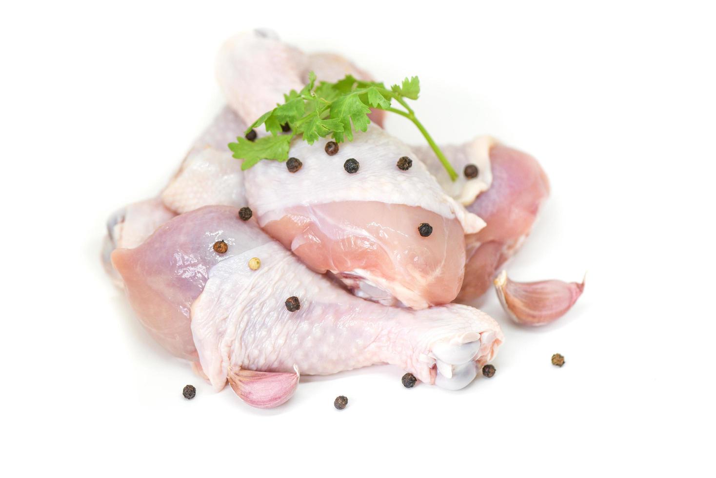 rauw kippenbeen met ingrediënten voor het koken van voedsel op witte achtergrond - vers ongekookt kippenvlees voor het koken van voedsel foto