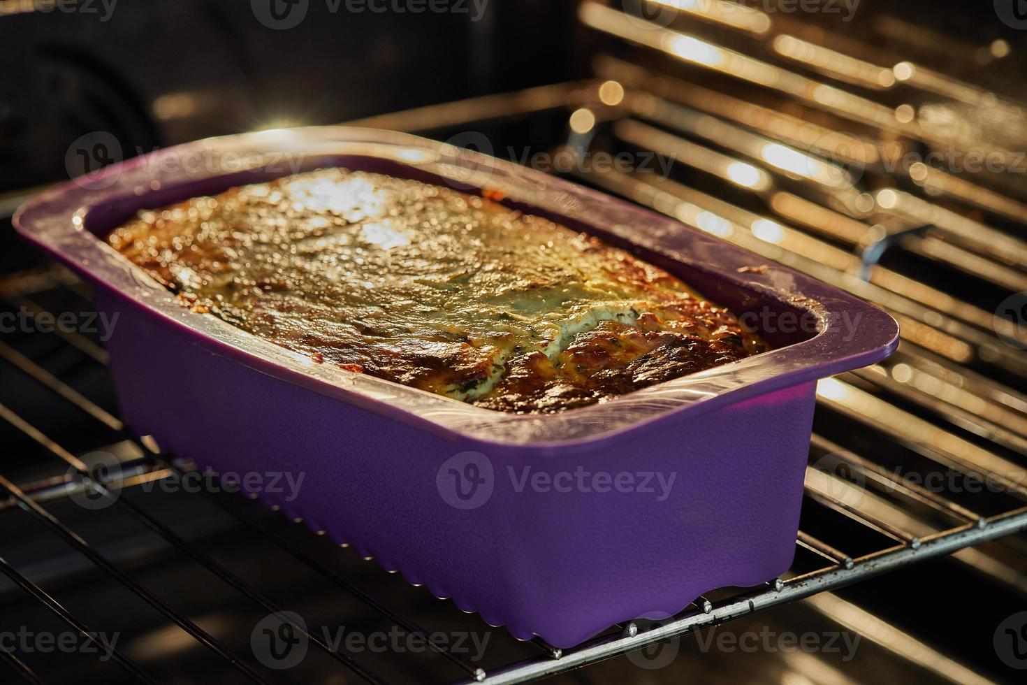 Aardappelen en kaasgratin in siliconenvorm in een elektrische oven na het bakken foto