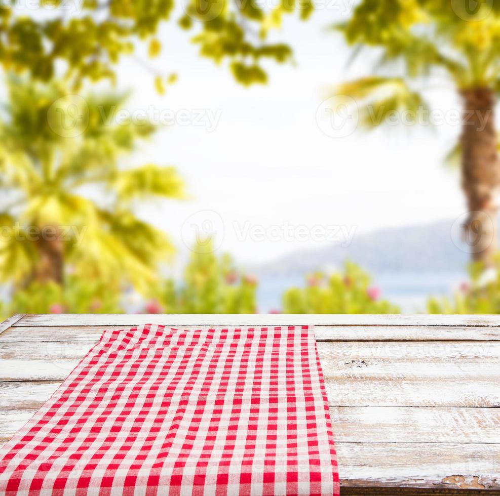 lege voedseltafel, rood tafelkleed op een wazige zomerparkachtergrond, kopieer ruimte foto