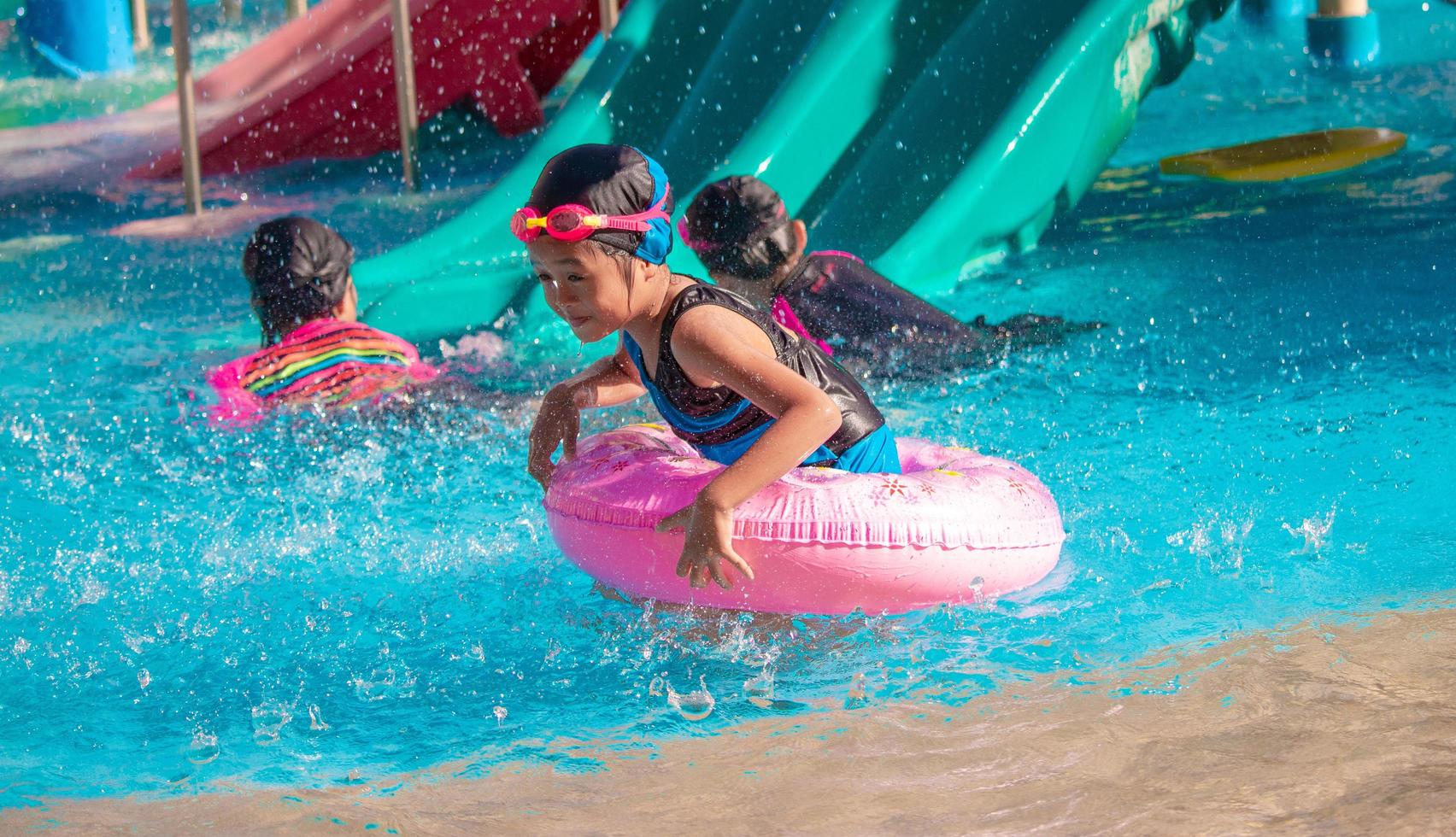 kinderen dartelen in het waterpark. het is een zonnige, perfecte dag om nat te worden en hard te spelen foto