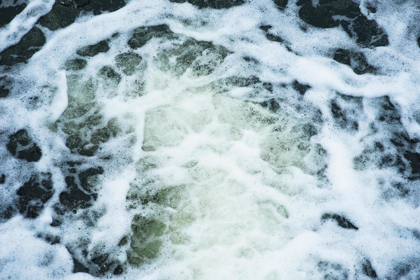 water stroomt snel in een cascade langs de betonnen wand van de dam. dam. foto