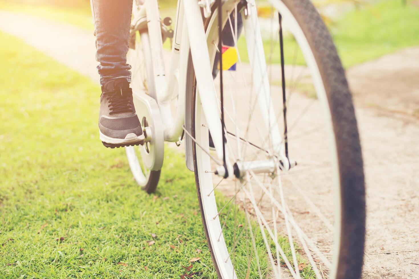 close-up van jonge hipstervrouw die haar voet op fietspedaal houdt. foto