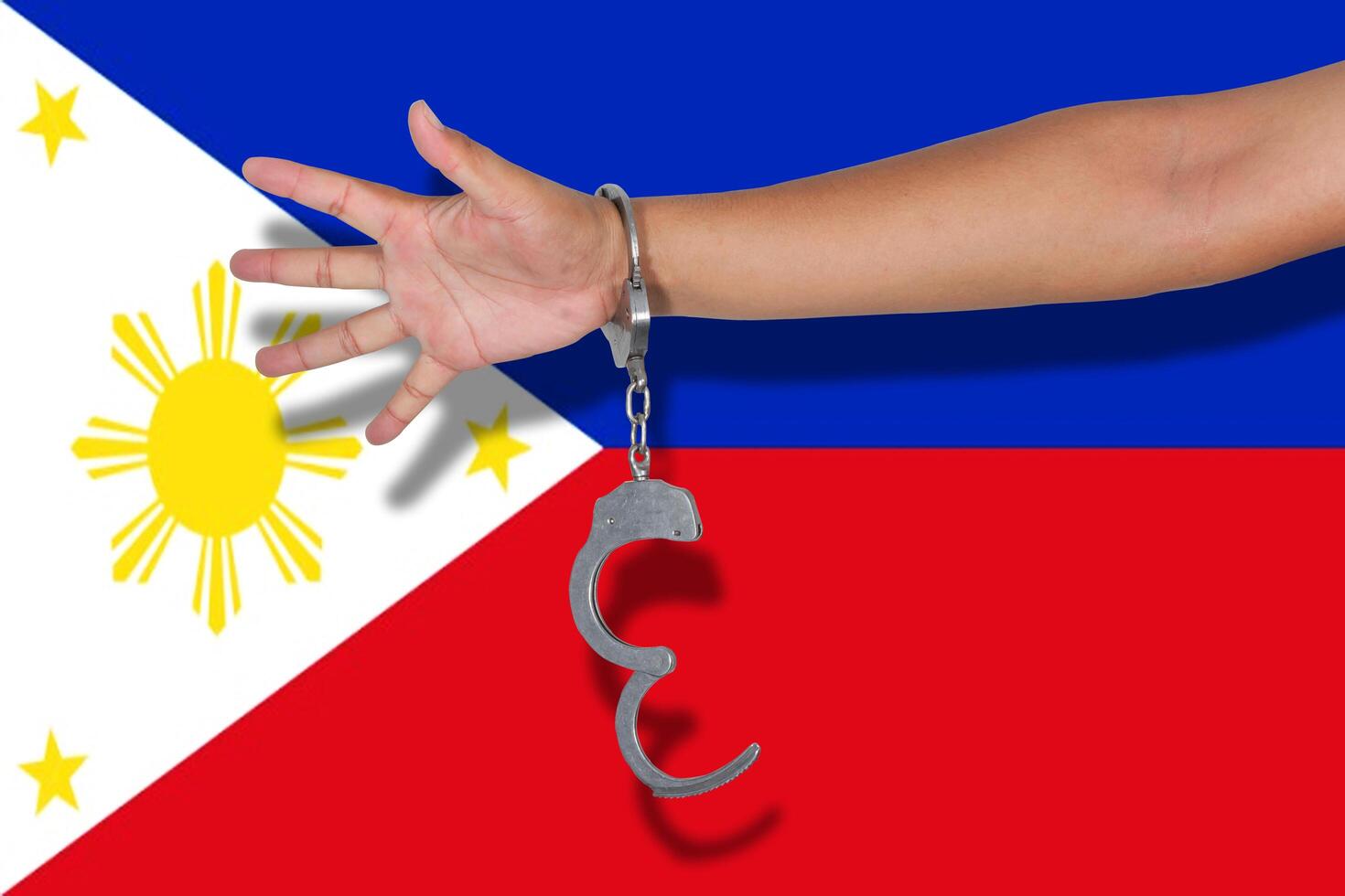 handboeien met hand op Filipijnse vlag foto