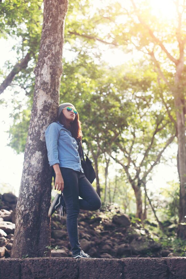 aantrekkelijk meisje permanent tegen boom, tijdens het reizen. foto