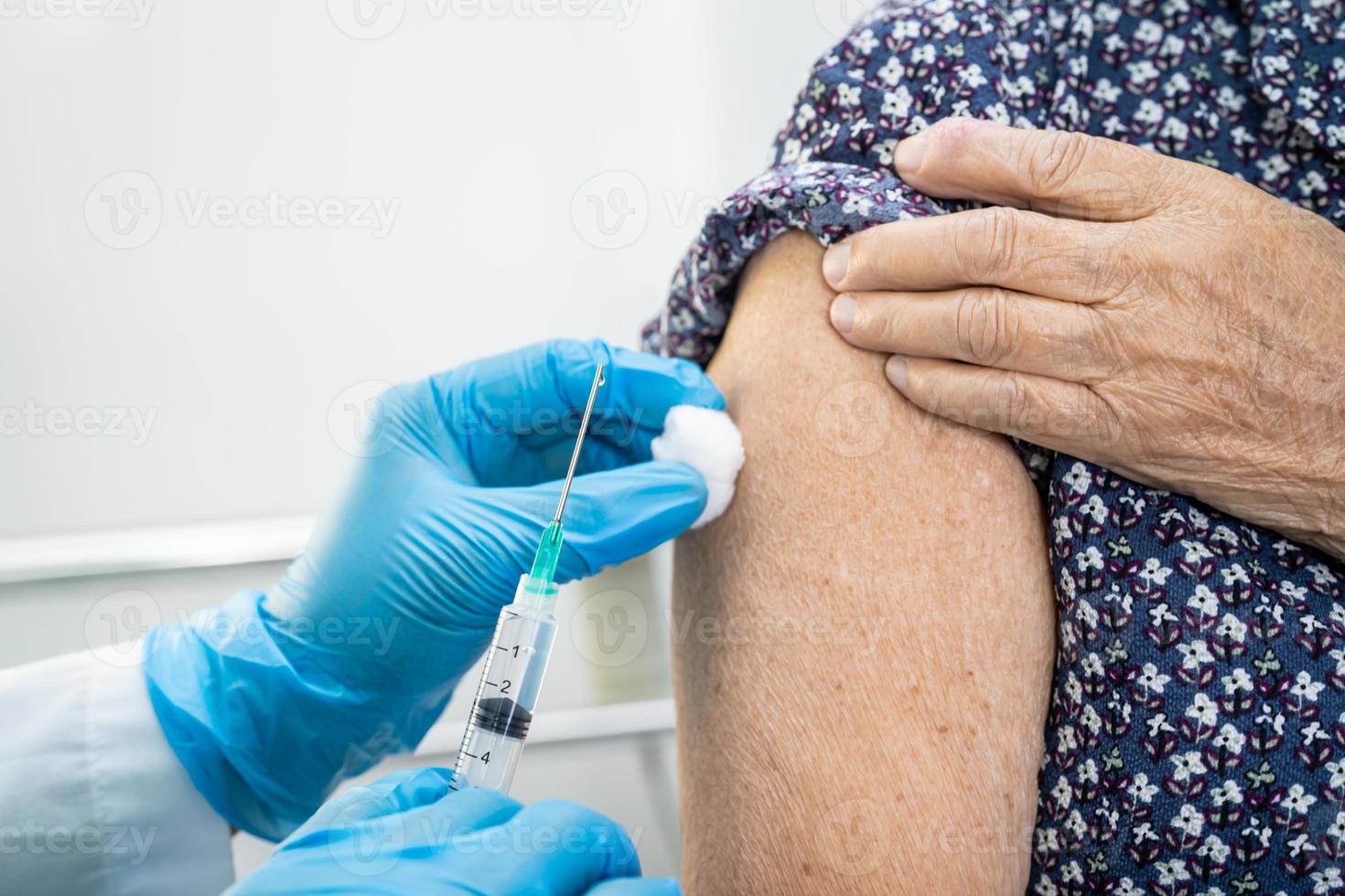 oudere aziatische senior vrouw die covid-19 of coronavirusvaccin krijgt door een arts, maakt injectie. foto