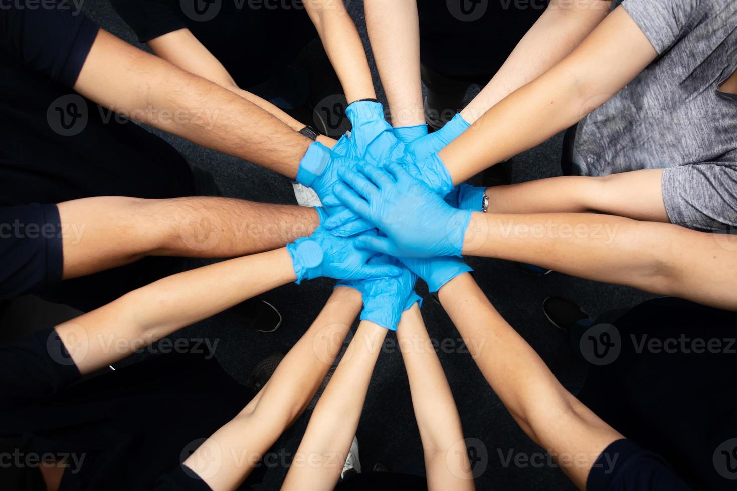 close-up bovenaanzicht van vrijwilligers die hun handen in elkaar slaan. stapel handen die eenheid tonen foto