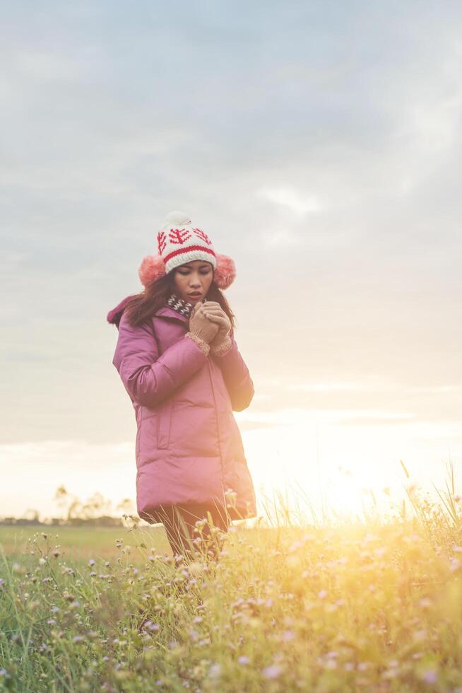 jonge vrouw speelde in een veld met bloemen in de winterlucht. foto