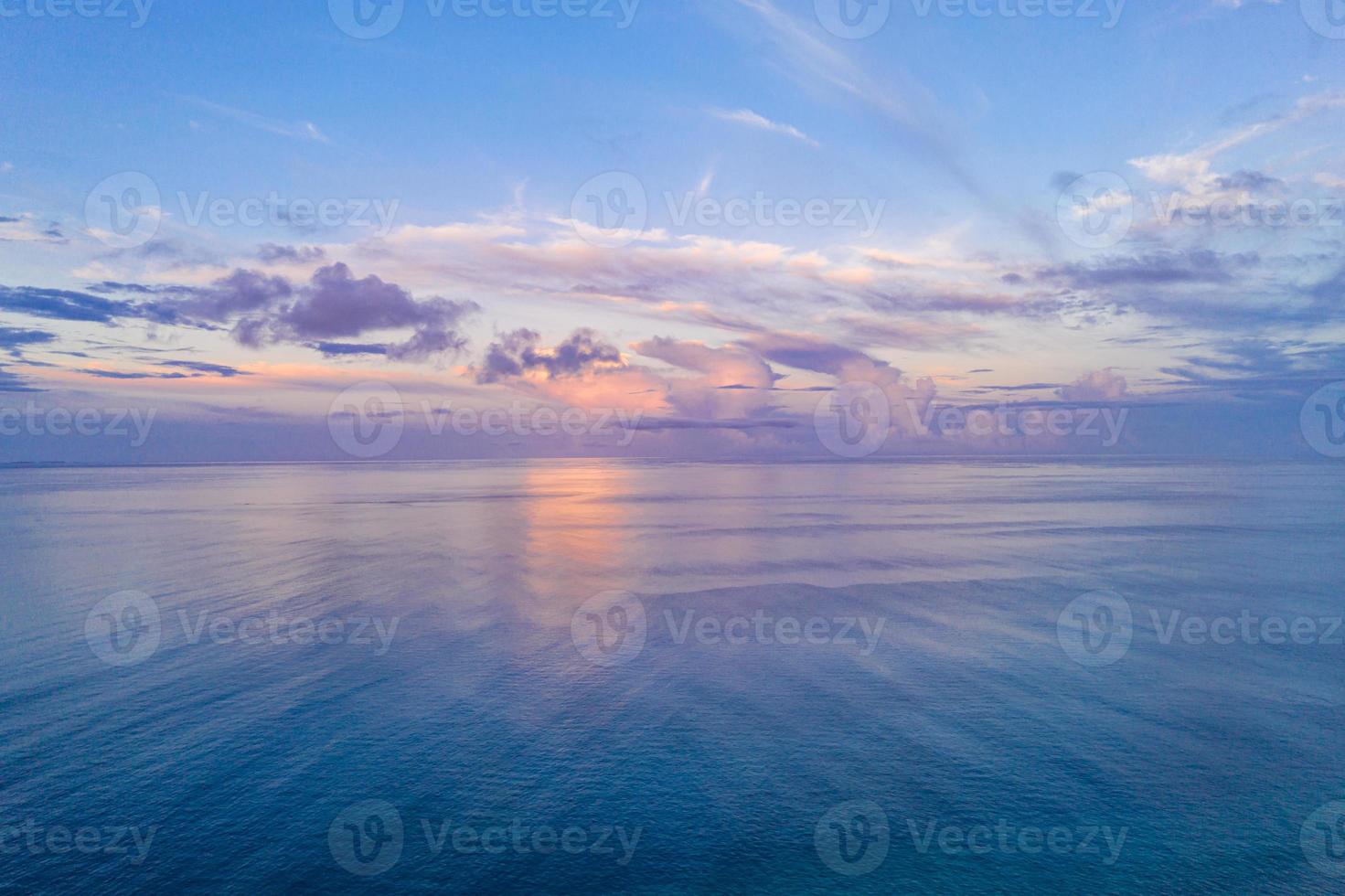 luchtfoto panoramisch uitzicht op de zonsondergang over de oceaan. kleurrijke lucht, wolken en water. mooie serene scène, ontspannende oceaanhorizon foto