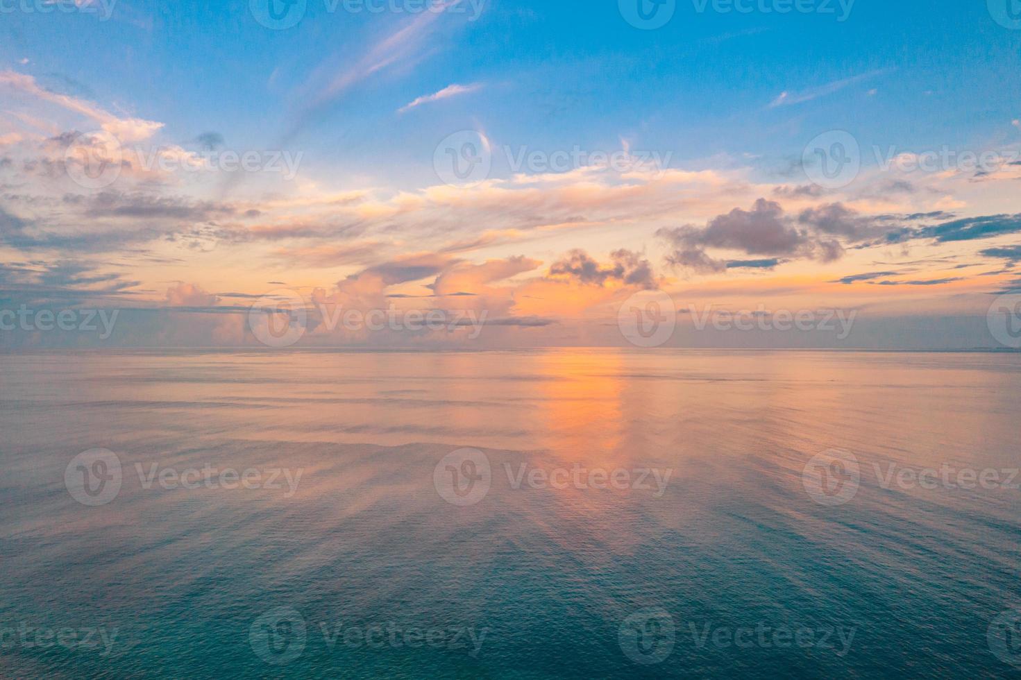 luchtfoto panoramisch uitzicht op de zonsondergang over de oceaan. kleurrijke lucht, wolken en water. mooie serene scène, ontspannende oceaanhorizon foto