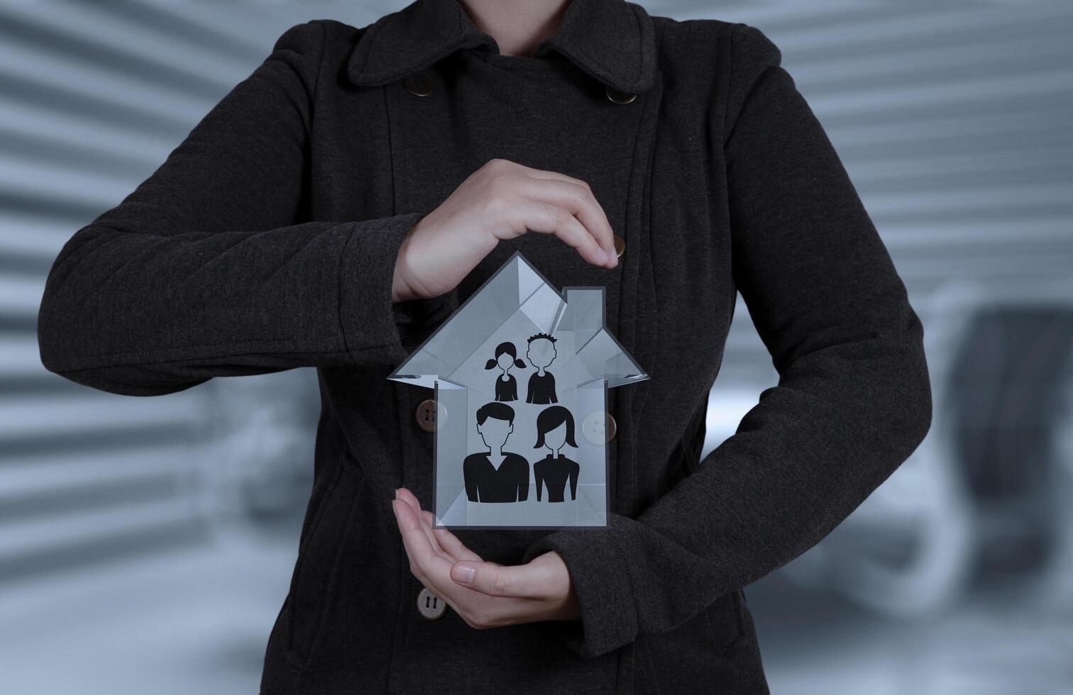 zakenmanhand die 3d huis met familiepictogram houden als verzekeringsconcept foto