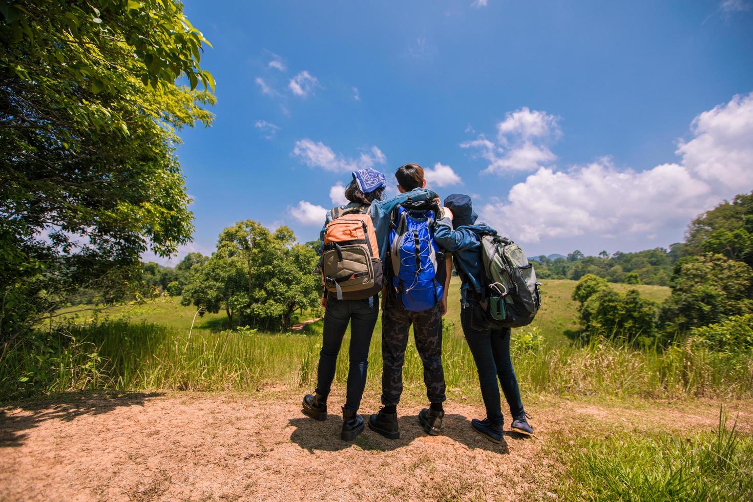 Aziatische groep jongeren wandelen met vrienden rugzakken samen wandelen en kaart kijken en fotocamera nemen langs de weg en er gelukkig uitzien, ontspannen tijd op vakantie concept reizen foto