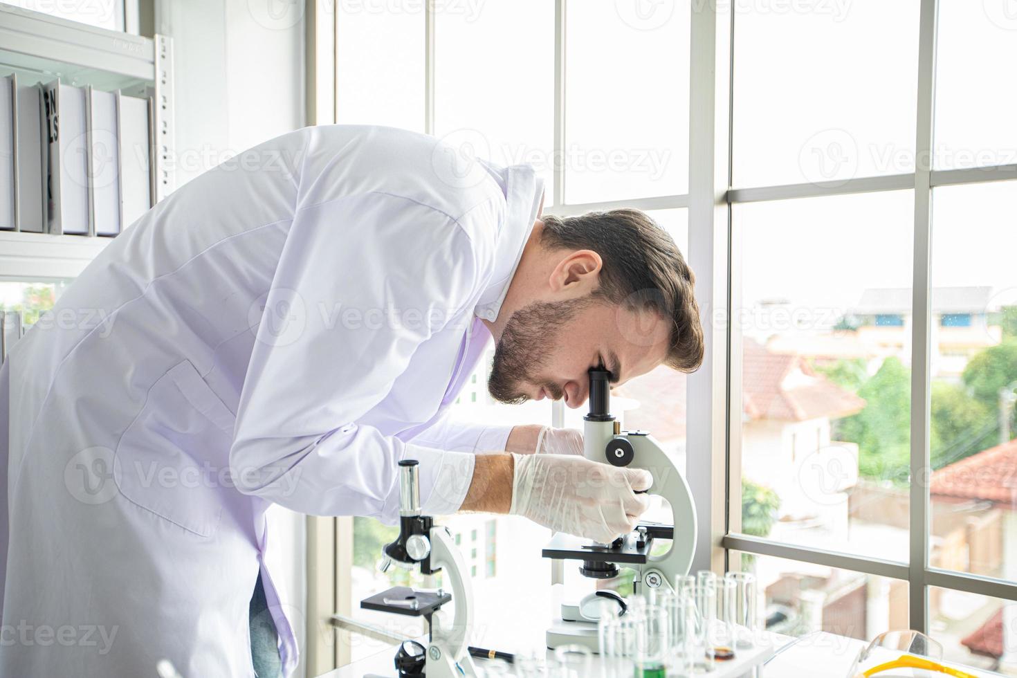 medisch onderzoek en wetenschappers werken met een microscoop en een tablet en reageerbuisjes, micropipet en analyseresultaten in een laboratorium. foto