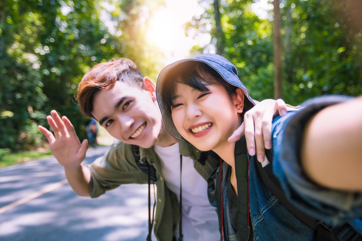Aziatische groep jongeren met vrienden en rugzakken die samen wandelen en gelukkige vrienden nemen foto en selfie, ontspannen tijd op vakantieconceptreizen