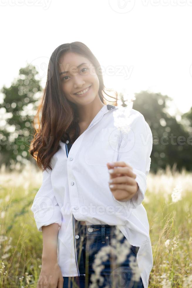 Aziatische vrouwen gelukkige glimlach op ontspannende tijd op de weide en gras foto