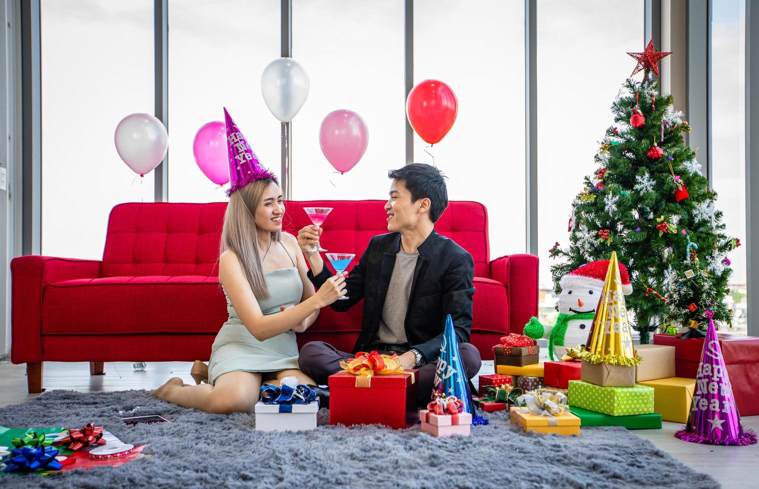 Aziatische paarminnaar die feest heeft met alcoholische bierdranken en jonge mensen die genieten aan een bar die cocktails roostert met kerstcadeau in kerstvakantie en gelukkig nieuwjaar patty foto