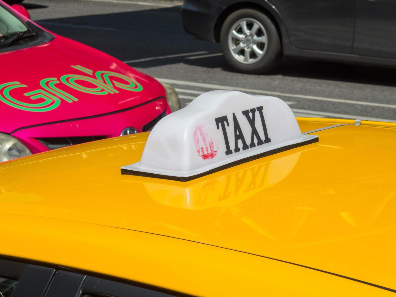 bangkok thailand30 oktober 2018taxi auto bord op de weg er is nog een taxi met een grabcar-logo. on.bangkok thailand30 oktober 2018 foto