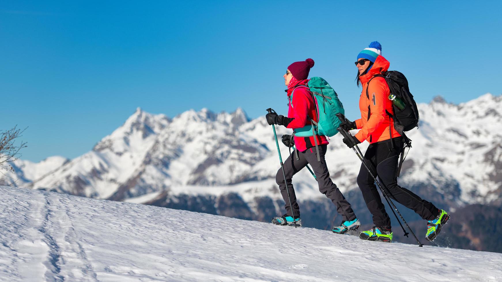 meisjes lopen met stijgijzers op de sneeuw in de bergen foto