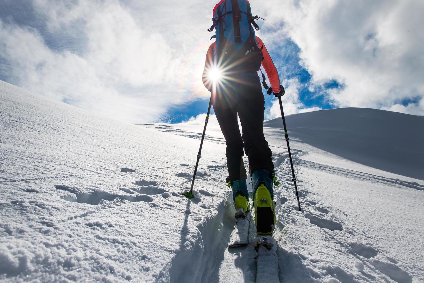 meisje bergbeklimmer klim op ski's en zeehondenhuiden foto
