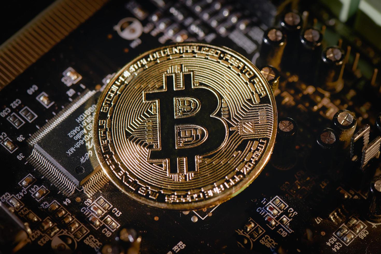 fysieke bitcoin-munt die op elektronische circuits rust foto