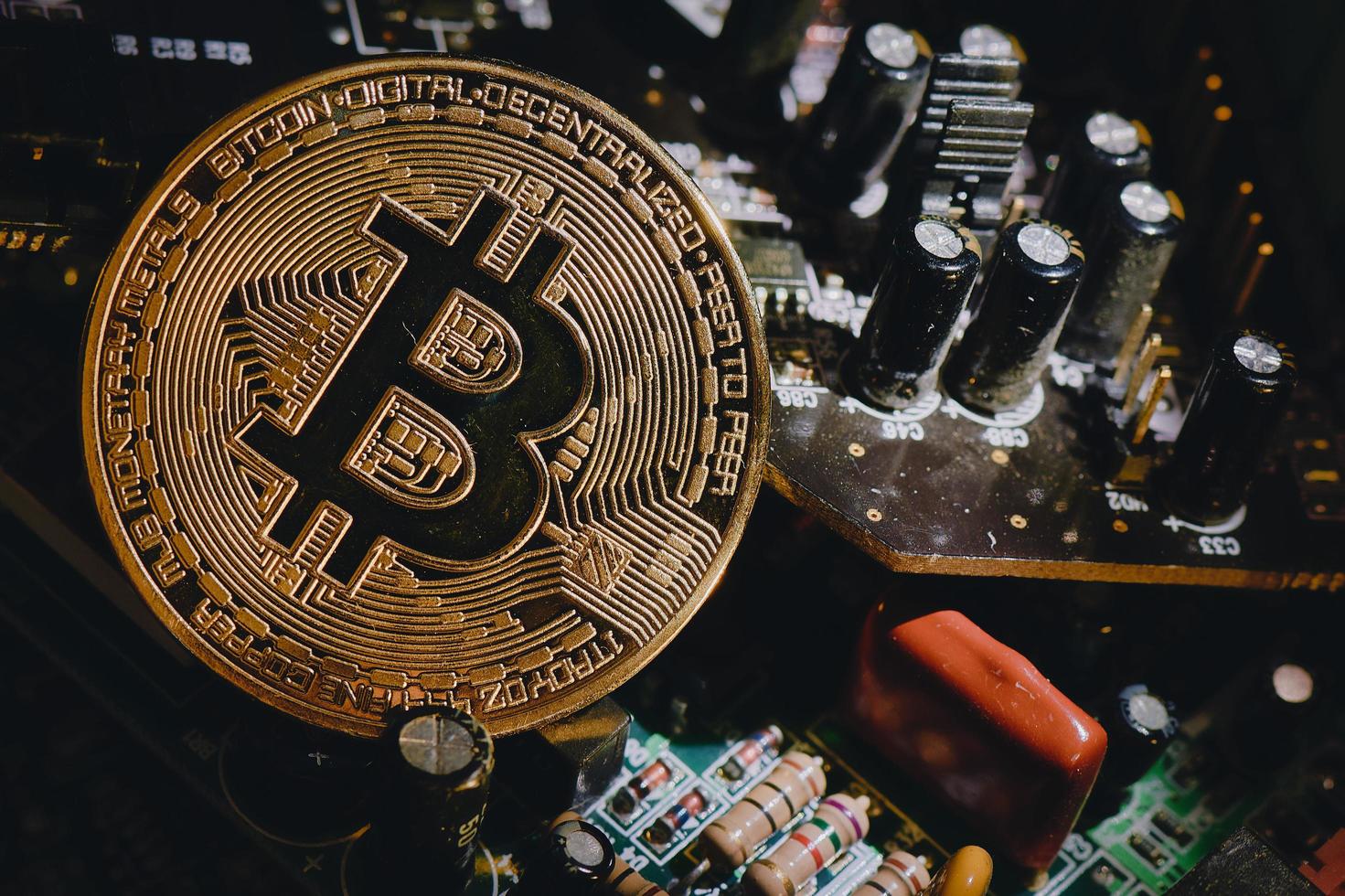 fysieke bitcoin-munt die op elektronische circuits rust foto